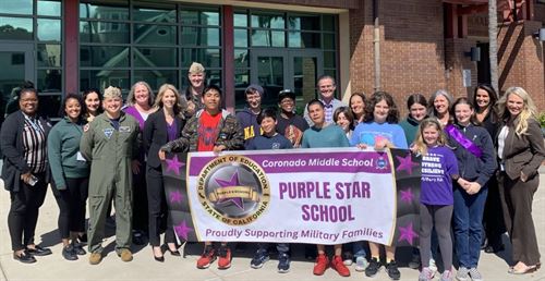 Photo of staff and students in front of Coronado Middle School holding the Purple Star Award banner.